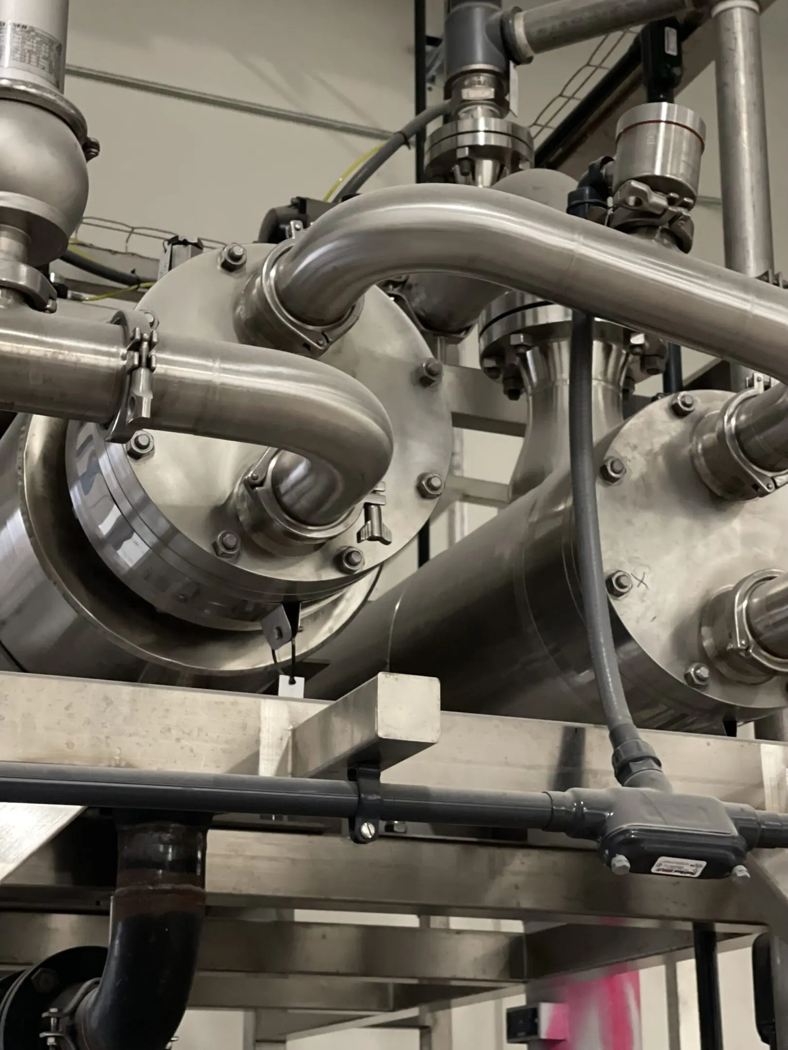 Close-up of industrial stainless steel pipes and machinery.