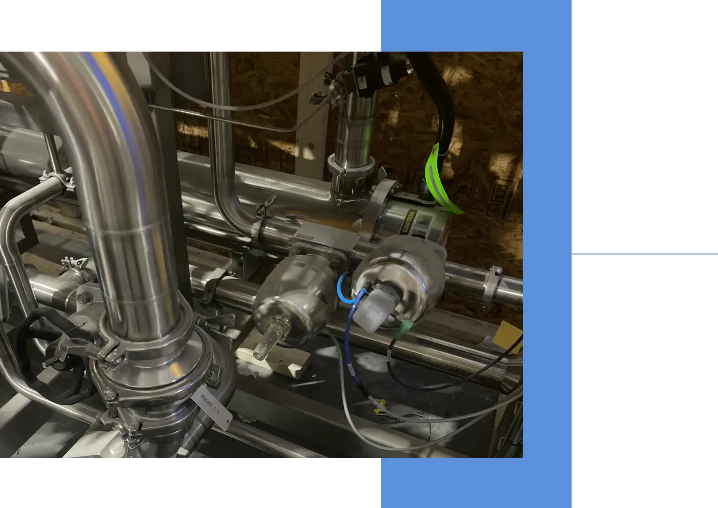 Close-up of industrial stainless steel pipes and valves in a mechanical setup.