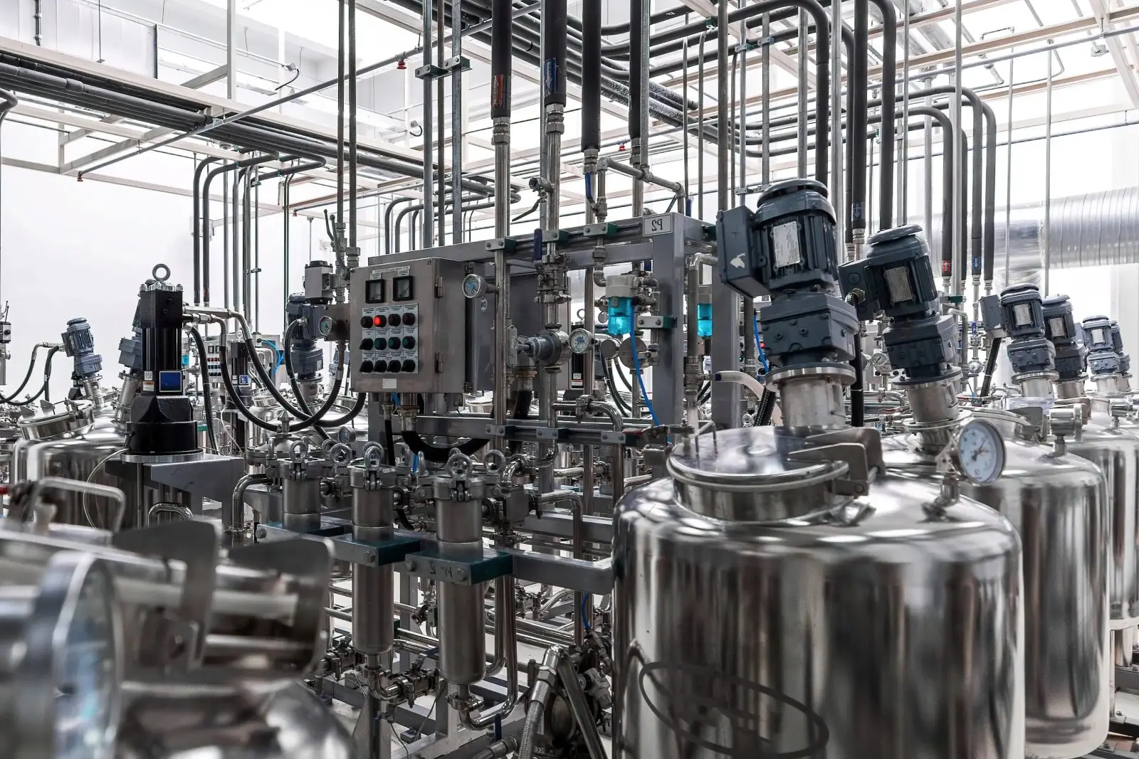 Industrial stainless steel tanks and pipes in a modern processing plant.